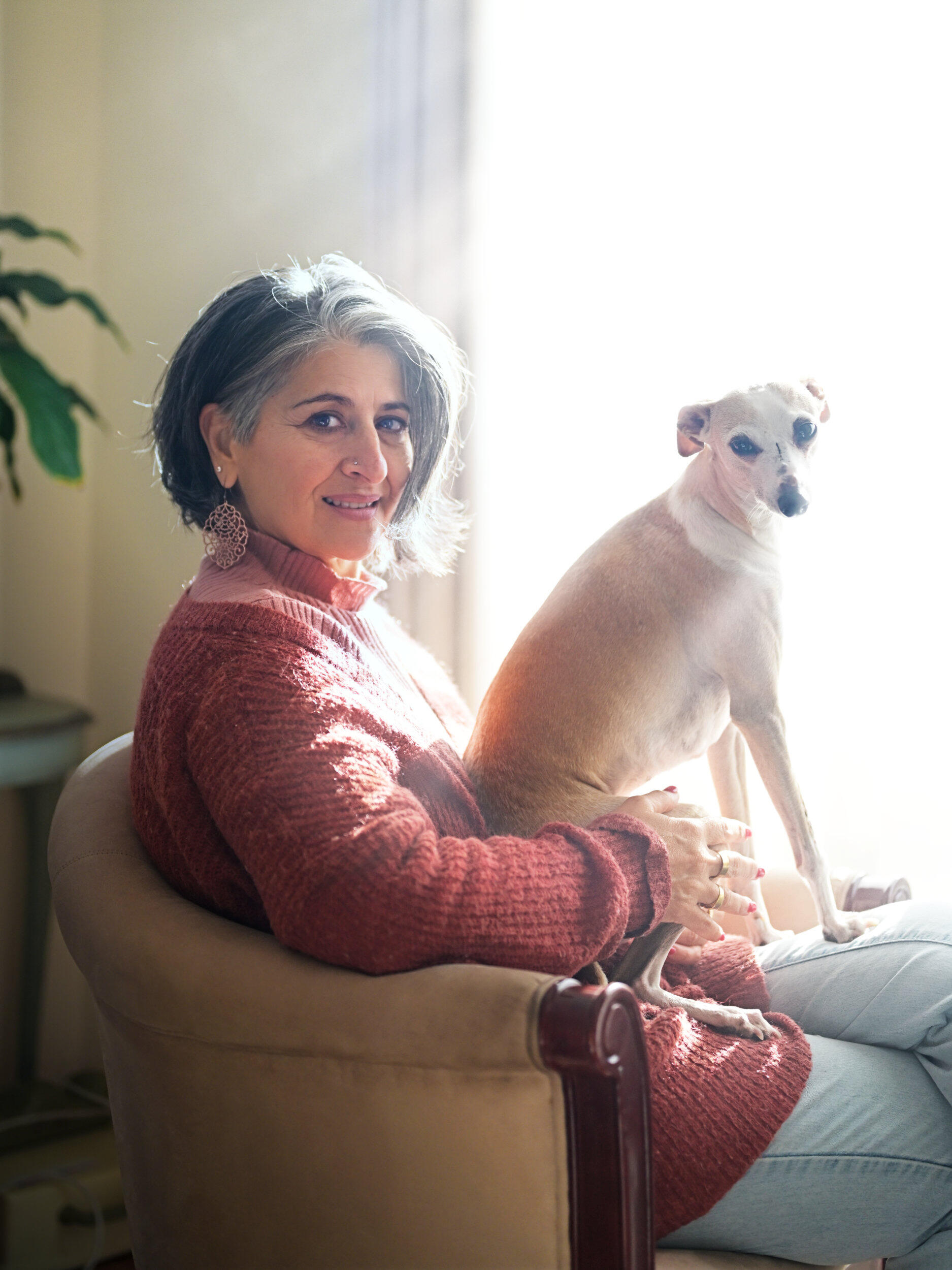 A woman and her dog enjoying the filtered afternoon sun through the window on a Melbourne winters day.